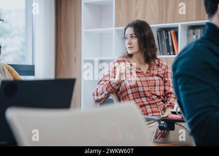 Jeune femme magnifique dans un environnement de bureau décontracté engagé dans la discussion. Banque D'Images