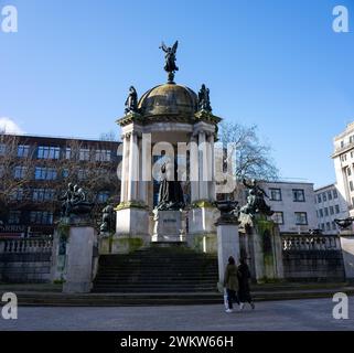 Liverpool, Royaume-Uni 12 février 2024 : deux touristes marchent pour admirer le monument de la Reine Victoria construit sur l'ancien site du château de Liverpool à Derby Square à L. Banque D'Images