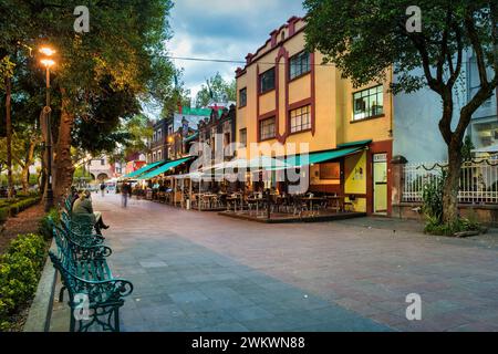 Les gens dînent sur les patios des restaurants dans le quartier historique de Coyoacan à Mexico, Mexique dans la soirée. Banque D'Images