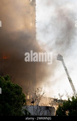 Valencia, Espagne - 22 février 2024 : des pompiers tentent d'accéder à l'incendie dans un immeuble résidentiel de 14 étages sur la rue Maestro Rodrigo avec le général Av Banque D'Images