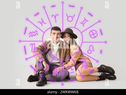 Portrait de jeune couple et signes dessinés du zodiaque sur fond clair. Horoscope de compatibilité d'amour. Mise en correspondance du partenaire par date de naissance Banque D'Images