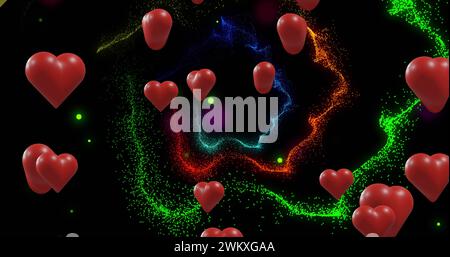 Image de coeurs colorés sur des traînées de lumière sur fond noir Banque D'Images