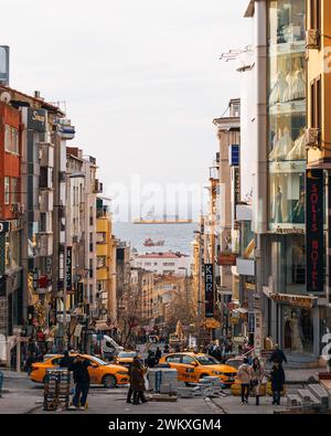 Une rue de ville animée de voitures, de gens et de gratte-ciel Banque D'Images