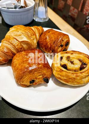 Pâtisseries assorties sur une assiette avec un bol de sucre en poudre sur une table Banque D'Images