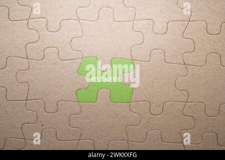 Pièce de puzzle manquant avec texte de récupération sur fond vert. Concept de reprise d'activité Banque D'Images