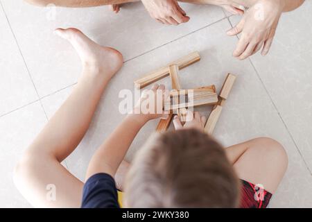 Les tweens jouant des blocs de construction en bois jouets ensemble dans un intérieur minimaliste léger Banque D'Images