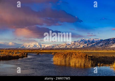 Le soleil de la fin de l'après-midi illumine les nuages et le paysage de Farmington Bay, Utah, regardant vers le nord au mont Ben Lomond (à gauche) et Mt. Ogden sur la droite. Banque D'Images