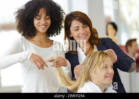 Jeune femme aux cheveux longs ayant hair stylist à salon Banque D'Images