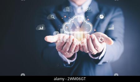 Homme d'affaires montrant l'informatique virtuelle brillante en nuage pour télécharger et charger des informations de données et télécharger sur l'application réseau du système. Données technologiques Banque D'Images
