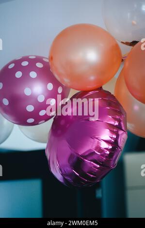 Des ballons colorés à pois planent du plafond Banque D'Images