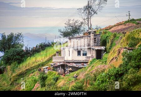 Une maison délabrée construite à flanc de colline dans les environs du parc national de Cotopaxi, à l'extérieur de Quito, Équateur en Amérique du Sud. La maison a été prolongée vers le haut avec des blocs de brise mais pas fini avec le rendu. Prise en 2000. Banque D'Images