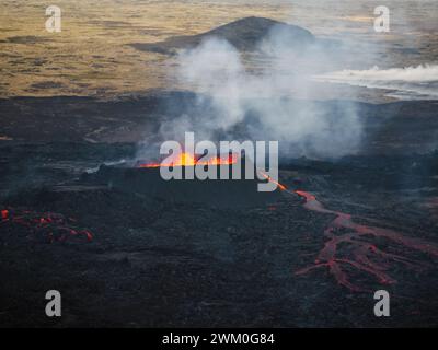 Lave coulant, magma chaud se déversant du cratère du volcan, vue latérale aérienne. Concepts d'éruption volcanique et terre islandaise de feu et de glace. Banque D'Images