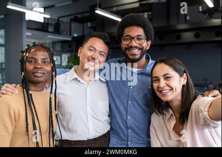 Heureuse femme d'affaires prenant selfie avec des collègues au bureau Banque D'Images