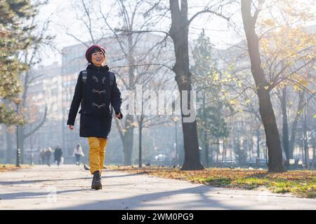 Femme heureuse marchant sur le sentier pédestre dans le parc Banque D'Images