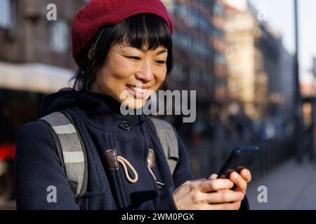 Femme mature heureuse utilisant un téléphone intelligent Banque D'Images