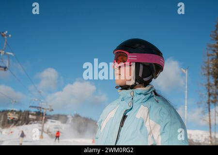 Fille portant un casque de sport à la station de ski Banque D'Images