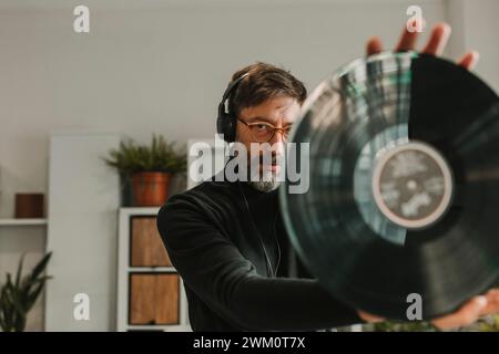 Homme écoutant de la musique et analysant le vinyle à la maison Banque D'Images