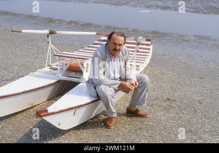 3825878 Tonino Guerra ; (Festival du film de Venise add.info.: 1983. Poète et scénariste italien Tonino Guerra assis sur un bateau à aubes à la plage du Lido / Mostra del Cinema di Venezia 1983. Tonino Guerra, poeta e sceneggiatore, seduto su un pedalò sulla spiaggia del Lido) ; © Marcello Mencarini. Tous droits réservés 2024. Banque D'Images