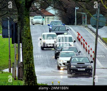 Glasgow, Écosse, Royaume-Uni. 23 février 2024. Météo Royaume-Uni : trafic aux heures de pointe dans le mouillé sur la grande route de l'ouest. De fortes pluies ont vu les habitants s'abriter sous des parapluies sur le style Mile et la capitale du shopping de l'Écosse Buchanan Street. Crédit Gerard Ferry/Alamy Live News Banque D'Images