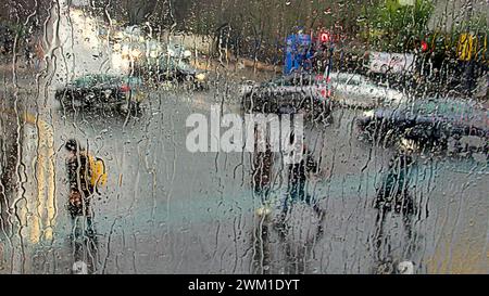 Glasgow, Écosse, Royaume-Uni. 23 février 2024. Météo Royaume-Uni : trafic dans le mouillé sur la grande route de l'ouest. De fortes pluies ont vu les habitants s'abriter sous des parapluies sur le style Mile et la capitale du shopping de l'Écosse Buchanan Street. Crédit Gerard Ferry/Alamy Live News Banque D'Images