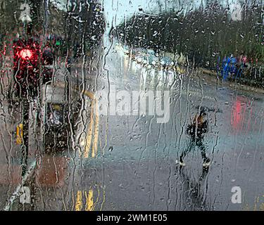 Glasgow, Écosse, Royaume-Uni. 23 février 2024. Météo Royaume-Uni : trafic dans le mouillé sur la grande route de l'ouest. De fortes pluies ont vu les habitants s'abriter sous des parapluies sur le style Mile et la capitale du shopping de l'Écosse Buchanan Street. Crédit Gerard Ferry/Alamy Live News Banque D'Images