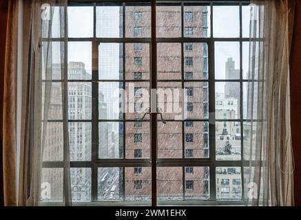 Chute de neige à travers une fenêtre à battants dans un appartement à Murray Hill, 2024, New York City, États-Unis Banque D'Images