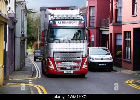 Camion poids lourd conduisant sur Rhosmaen Street devant les voitures garées devant les magasins la route étroite principale à travers la ville de Llandeilo Carmarthenshire pays de Galles UK 2024 Banque D'Images