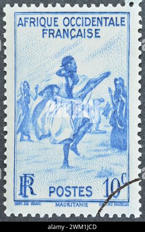 Timbre-poste oblitéré imprimé par l'Afrique de l'Ouest française, qui montre Mauritanie - Rifle Dance in the Trarza, vers 1947. Banque D'Images