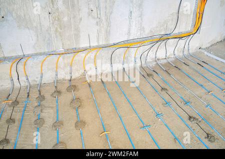 Chantier de construction : pose de câble sur béton pour plancher chaud Banque D'Images