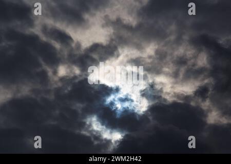 Une éclipse solaire partielle du 25 octobre 2022 capturée à travers des nuages sombres de mauvaise humeur, la phase maximale visible depuis l'Europe, la Roumanie. Banque D'Images