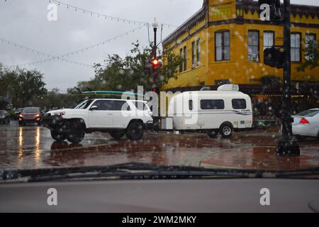 Petit camping-car remorqué par SUV avec planches de surf sur le dessus de Sanford, Floride Banque D'Images