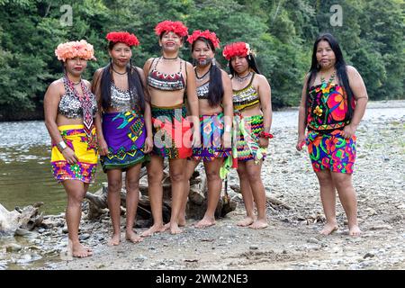 Femmes de la tribu Embera dans leurs vêtements traditionnels avec des fleurs dans la tête debout près de la rivière et leur village dans la jungle, Panama Banque D'Images