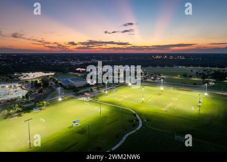 Les sportifs s'entraînent dans le match de football sur le stade de football illuminé dans le parc sportif public à North Port, en Floride Banque D'Images