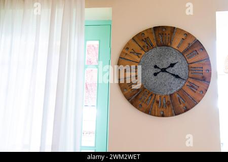 Grande horloge accrochée au mur à côté de la fenêtre Banque D'Images