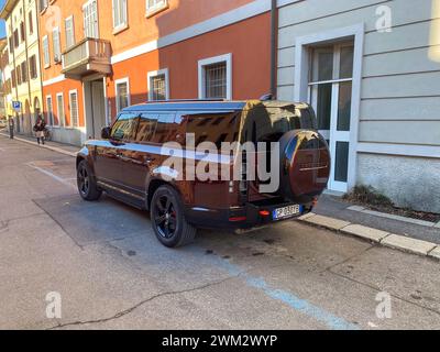 Cremona, Italie - 15 février 2024 Land Rover Defender 130 se Sedona Red suv 4x4 véhicule en position de stationnement. Banque D'Images