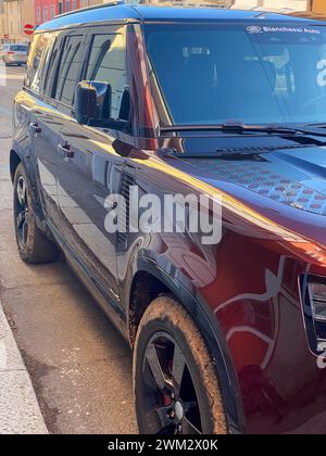 Cremona, Italie - 15 février 2024 Land Rover Defender 130 se Sedona Red suv 4x4 véhicule en position de stationnement. Banque D'Images