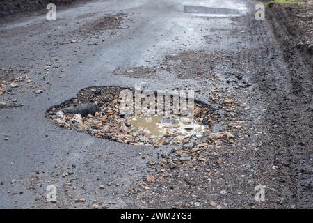 Un nid de poule dans une route de campagne, Angleterre, Royaume-Uni Banque D'Images