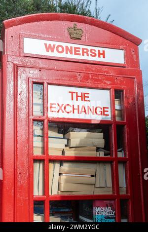 Vieille boîte de téléphone rouge dans le village de Wonersh étant utilisé comme un échange pour des livres et des puzzles, Surrey, Angleterre, Royaume-Uni Banque D'Images