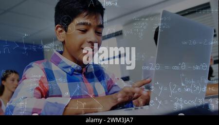 Image d'équations mathématiques sur écolier utilisant un ordinateur portable en classe Banque D'Images