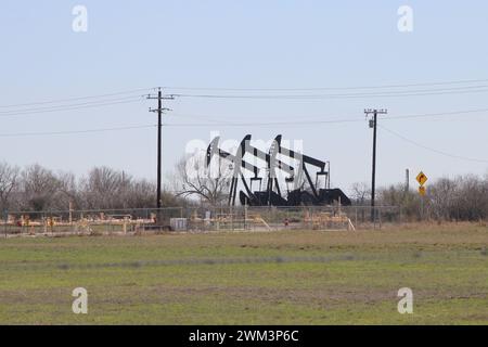 Falls City, États-Unis. 23 février 2024. Vérins de pompe à huile sur une plate-forme de puits près de la ville de Falls City, Texas, États-Unis, le 23 février 2024. Falls City et le comté environnant de Karnes est l'un des 30 comtés qui composent la zone connue sous le nom de zone de production de pétrole et de gaz de schiste Eagle Ford. Récemment, la région autour de Falls City a connu une augmentation de l'activité sismique, y compris 23 tremblements de terre depuis le 11 février 2024. Les experts ont lié de nombreux tremblements de terre au Texas au processus d'extraction de pétrole et de gaz connu sous le nom de fracturation hydraulique. (Photo de Carlos Kosienski/Sipa USA) crédit : Sipa USA/Alamy Live News Banque D'Images