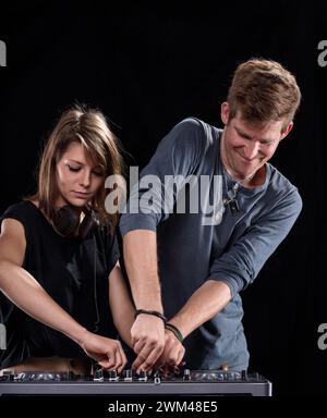 Dans la cabine DJ, un échange amical autour des platines met en lumière le plaisir dans les coulisses Banque D'Images