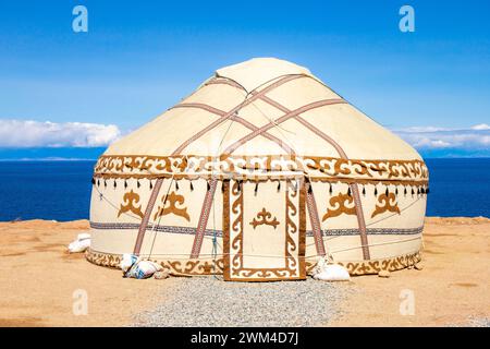 Yourte traditionnelle. Maison nationale nomade ancienne d'Asie centrale avec ciel bleu sur fond. Lac alpin Issyk Kul dans les montagnes Tian Shan. Kyrgy Banque D'Images