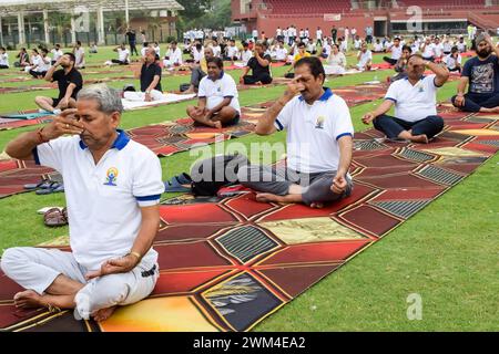 New Delhi, Inde, 21 juin 2023 - séance d'exercices de yoga en groupe pour les personnes au complexe sportif Yamuna à Delhi lors de la Journée internationale du yoga, grand groupe d'ADU Banque D'Images