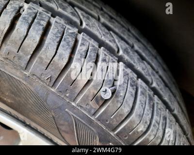 vieille vis rouillée ou clou à l'intérieur d'un pneu de voiture qui a causé un dommage et le pneu doit être réparé ou remplacé, concept de service de mécanicien de voiture, pointe de pneu esprit Banque D'Images