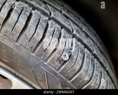 vieille vis rouillée ou clou à l'intérieur d'un pneu de voiture qui a causé un dommage et le pneu doit être réparé ou remplacé, concept de service de mécanicien de voiture, pointe de pneu esprit Banque D'Images