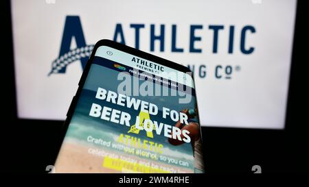 Téléphone portable avec le site Web de la société américaine de boissons Athletic Brewing Company devant le logo de l'entreprise. Concentrez-vous sur le coin supérieur gauche de l'écran du téléphone. Banque D'Images