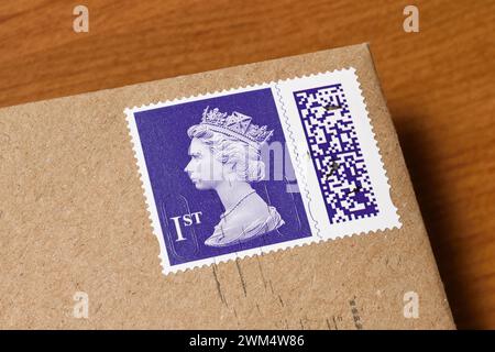 Un timbre de première classe à code-barres Royal mail sur une enveloppe marron Banque D'Images