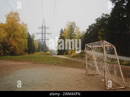 But de football et ligne électrique dans la forêt d'automne Banque D'Images