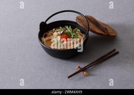 Soupe coréenne de nouilles ramen dans un bol avec des baguettes sur fond gris Banque D'Images