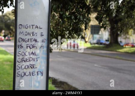 Graffiti sur un arrêt de bus 'L'argent numérique et l'identité numérique sont pour une société de pointage de crédit social' Banque D'Images